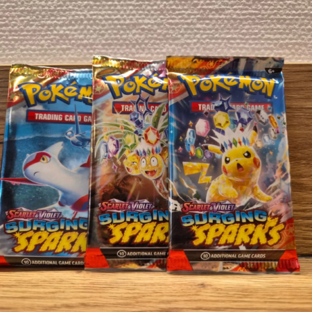 Drie Pokémon Surging Sparks booster packs uit de Scarlet & Violet serie met verschillende pack artworks